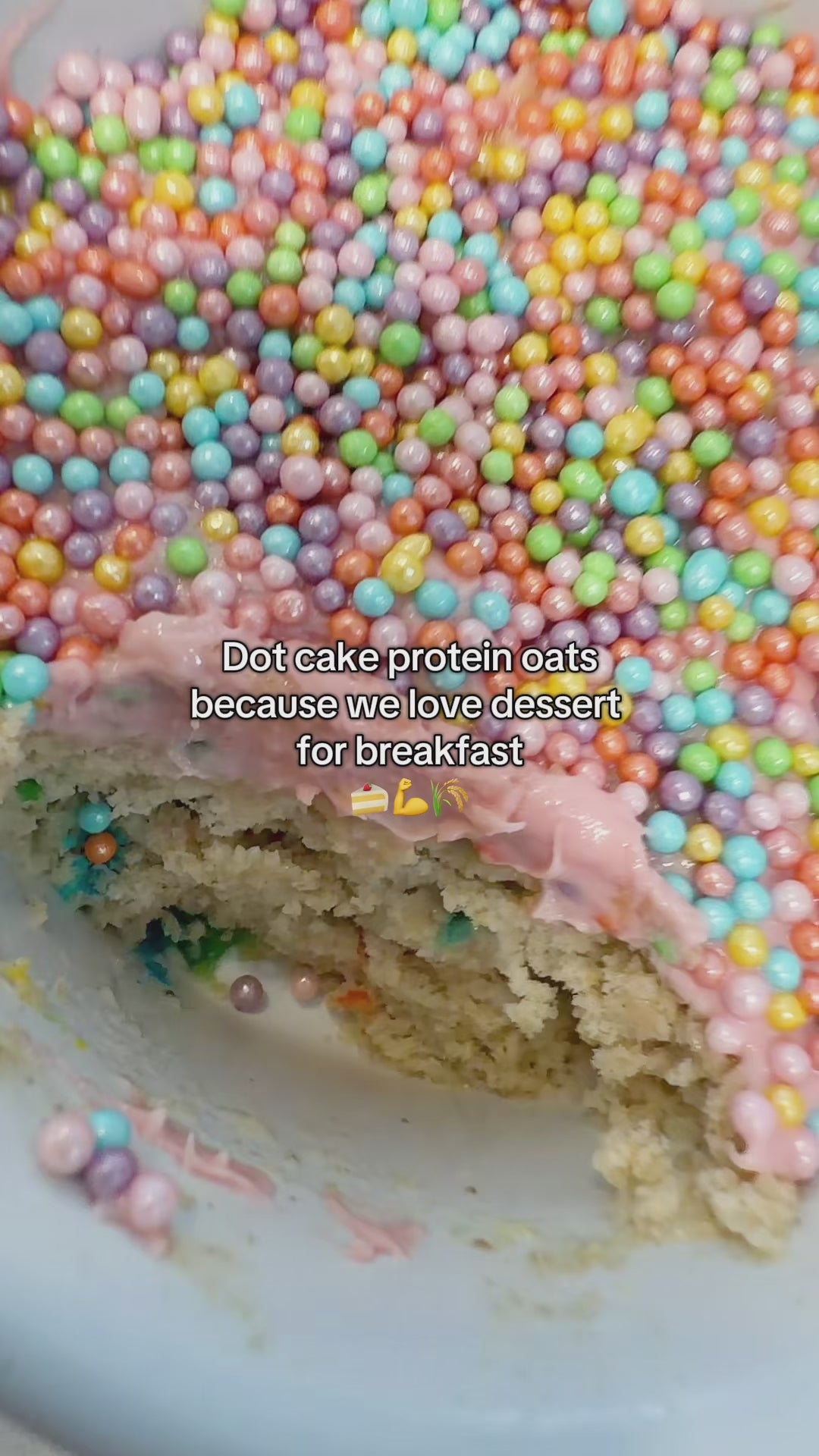 Load video: This video shows our founder mixing the birthday cake breakfast mix with water in a clear mug. She heats it up in the microwave for 30 seconds then spreads pink chocolate and sprinkles on top to make a high protein "dot cake."